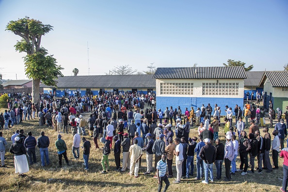 Zambian voters queue up in long lines to cast their ballots at a polling station in Lusaka on August 12, 2021. - Zambians were voting in a general election on August 12, after a tense campaign dominated by economic woes, a debt crisis and the impact of the coronavirus